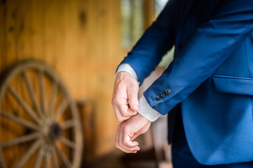 Détail du costume du marié ajustant sa manche