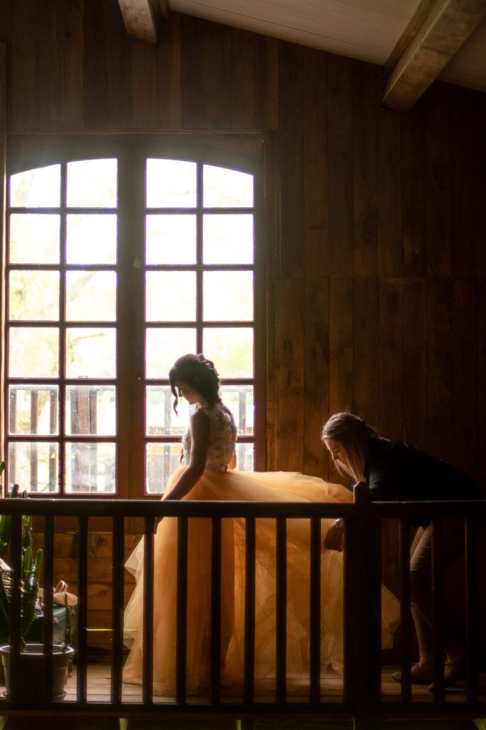 Mariée en robe de mariage lors des préparatifs près d'une fenêtre