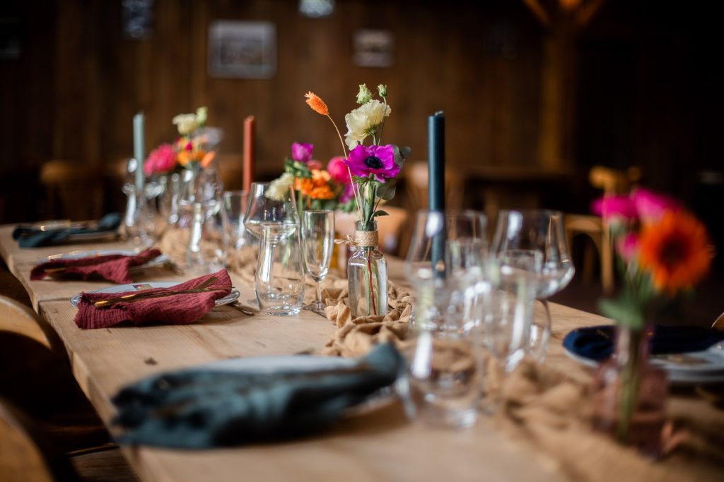 Décoration de table de mariage avec fleurs et bougies dans une salle en bois