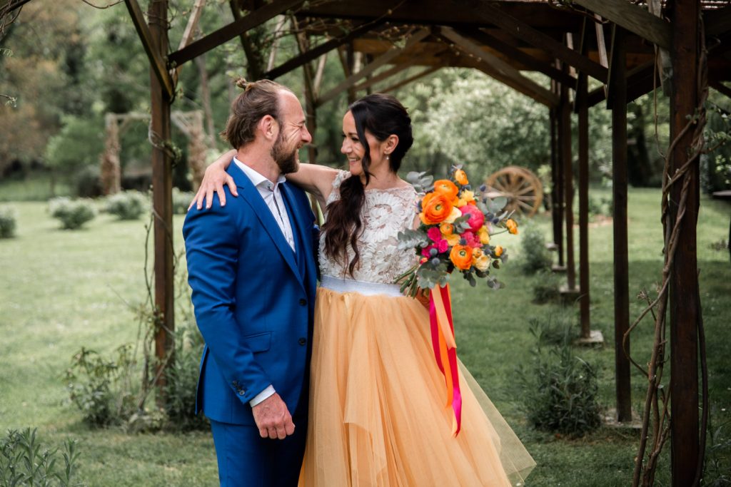 Regard complice des mariés après leur first look sous une pergola dans les Landes