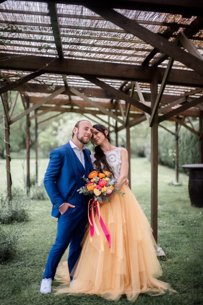 Mariés s’embrassant sous une pergola en bois dans un cadre naturel des Landes