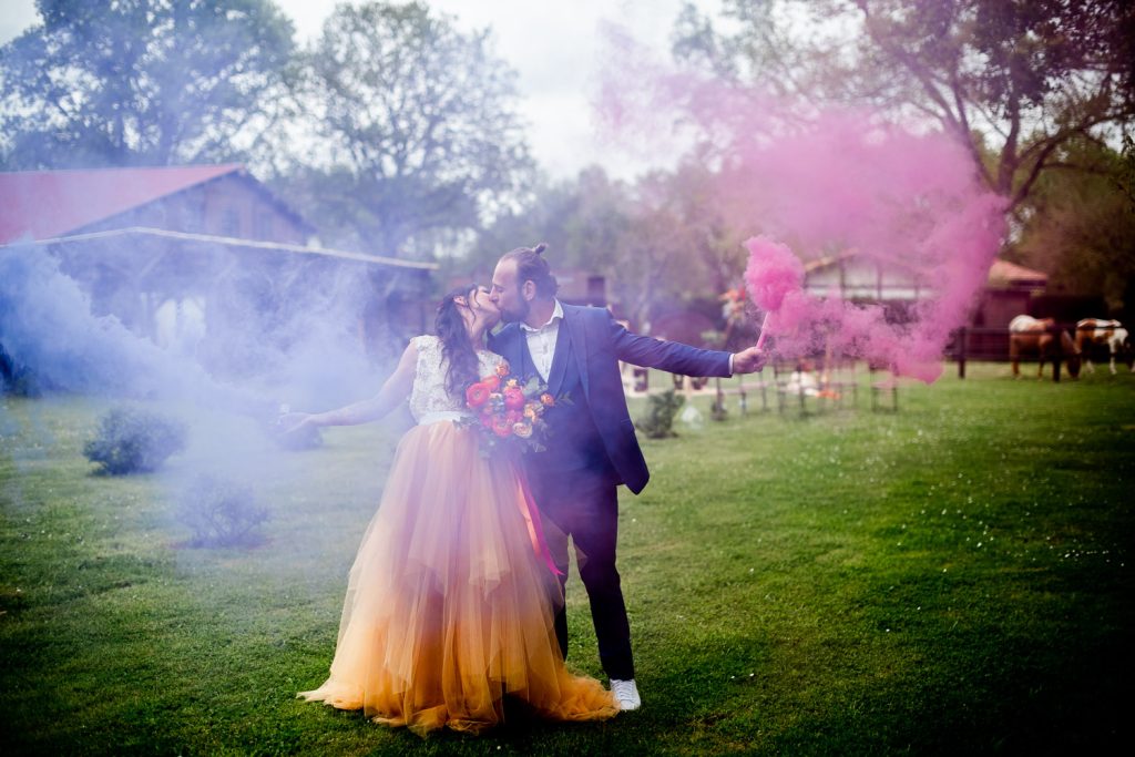 Mariés posant avec fumigènes colorés dans un cadre naturel des Landes