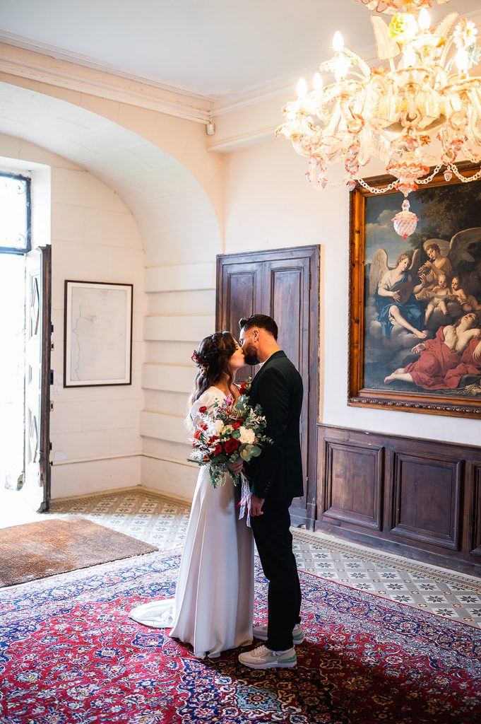 mariés qui s’embrassent intérieur château mariage hivernal Landes