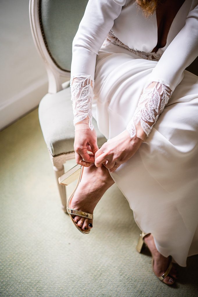 mariée en train de mettre ses chaussures préparation mariage intime