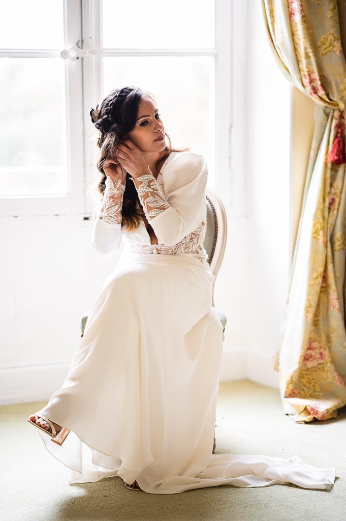 mariée assise près fenêtre lumière naturelle robe élégante mariage