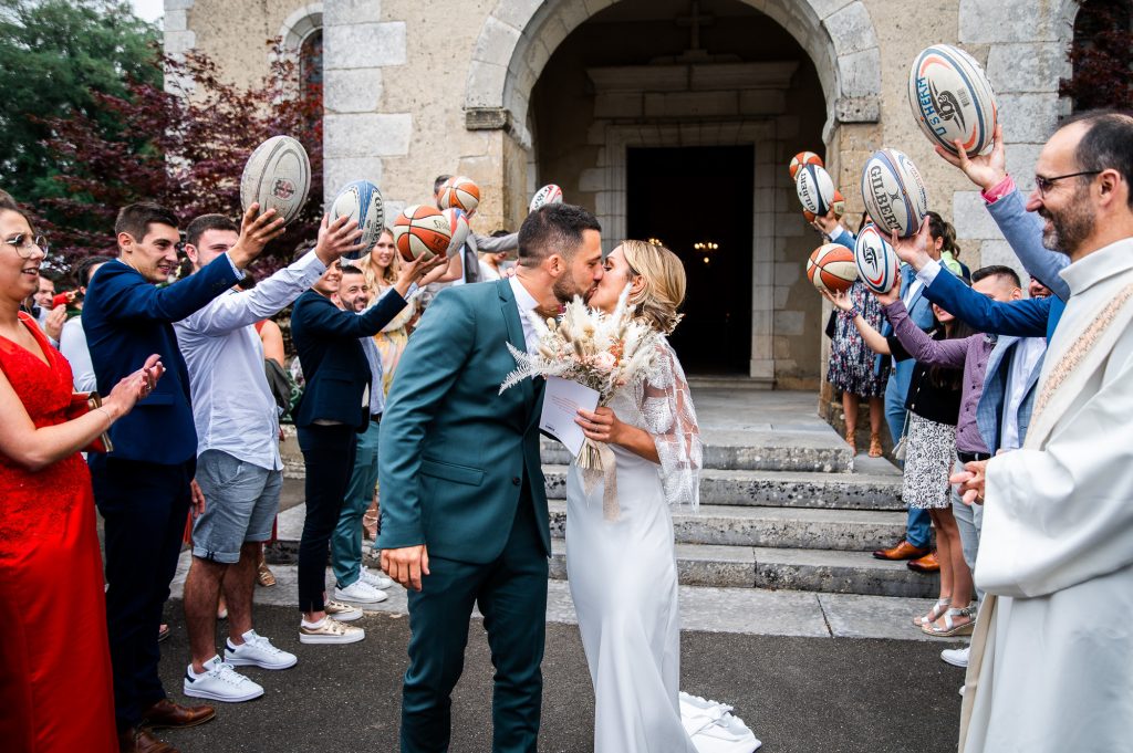 mariés qui s'embrassent à la sortie de l'église dans les Landes