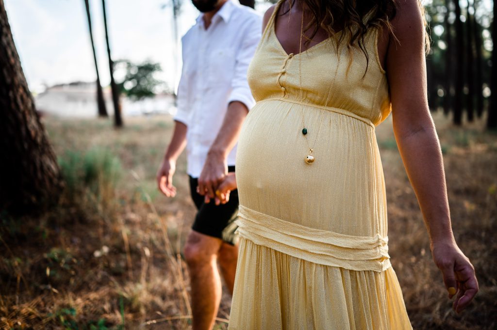 détail ventre de grossesse en robe jaune lors d’une séance photo grossesse à Mimizan dans les Landes