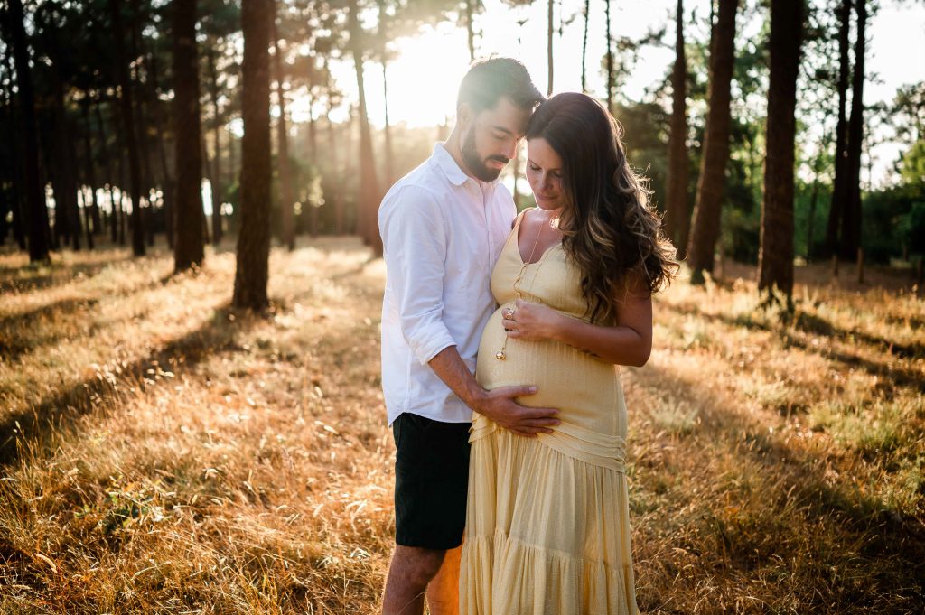 futur papa posant les mains sur le ventre de sa compagne séance photo grossesse Mimizan