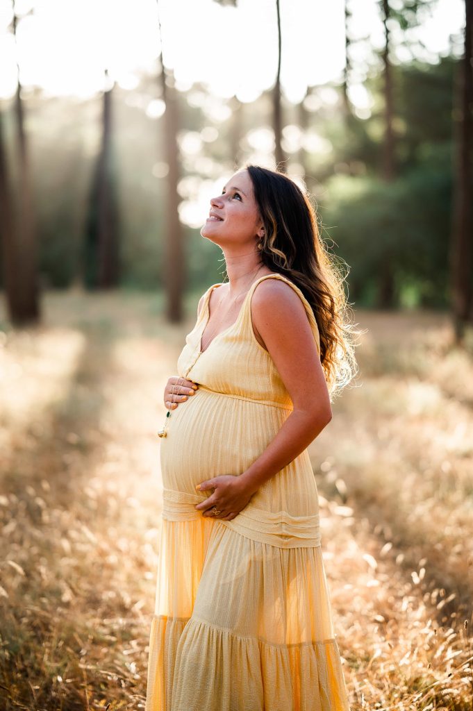portrait de femme enceinte en robe jaune dans la forêt à Mimizan dans les Landes