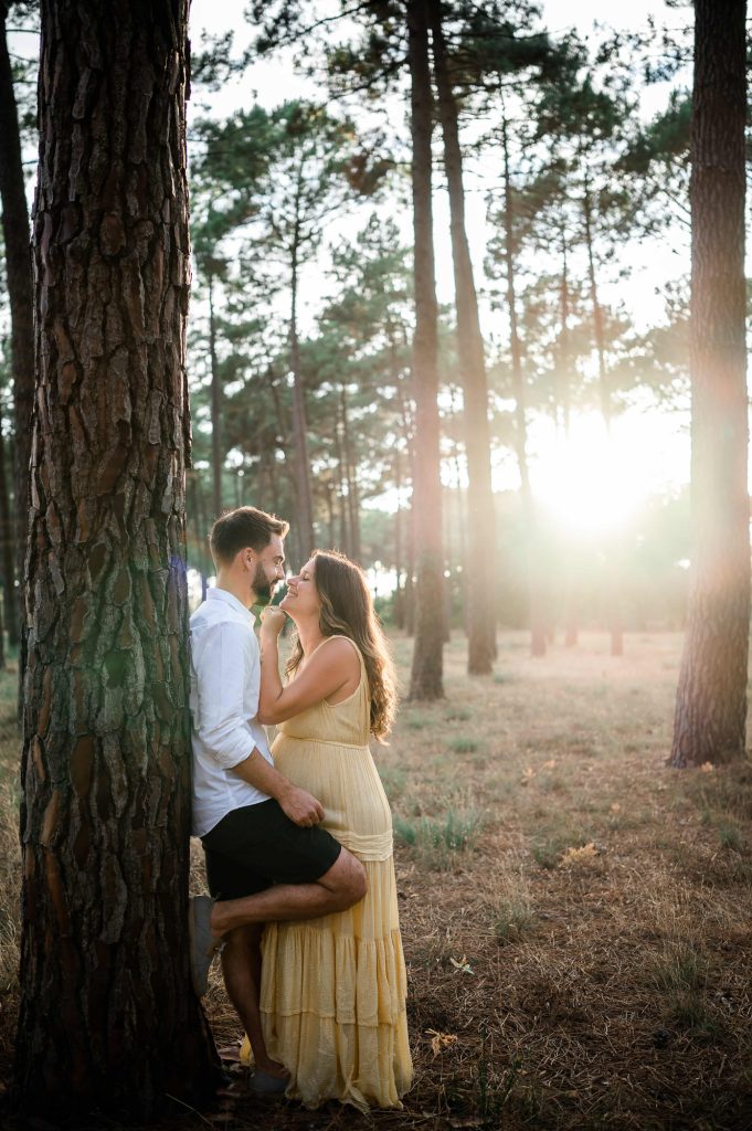 couple amoureux contre un pin pendant une séance photo grossesse à Mimizan