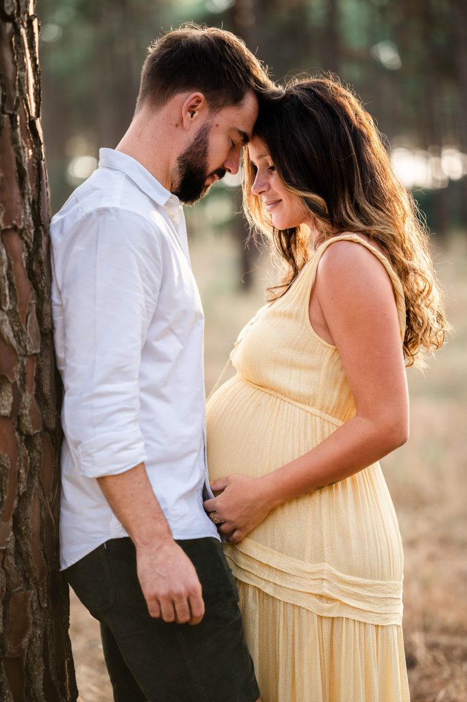 moment tendre entre futurs parents dans la forêt pendant une séance grossesse dans les Landes