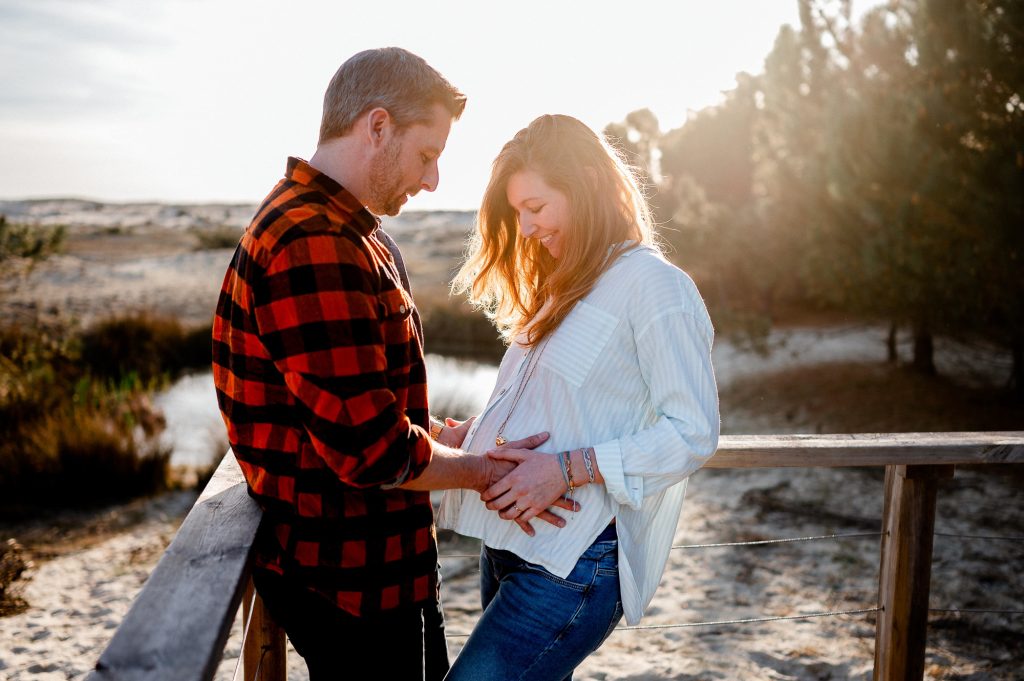 femme enceinte embrassant son compagnon séance photo grossesse naturelle Biscarrosse