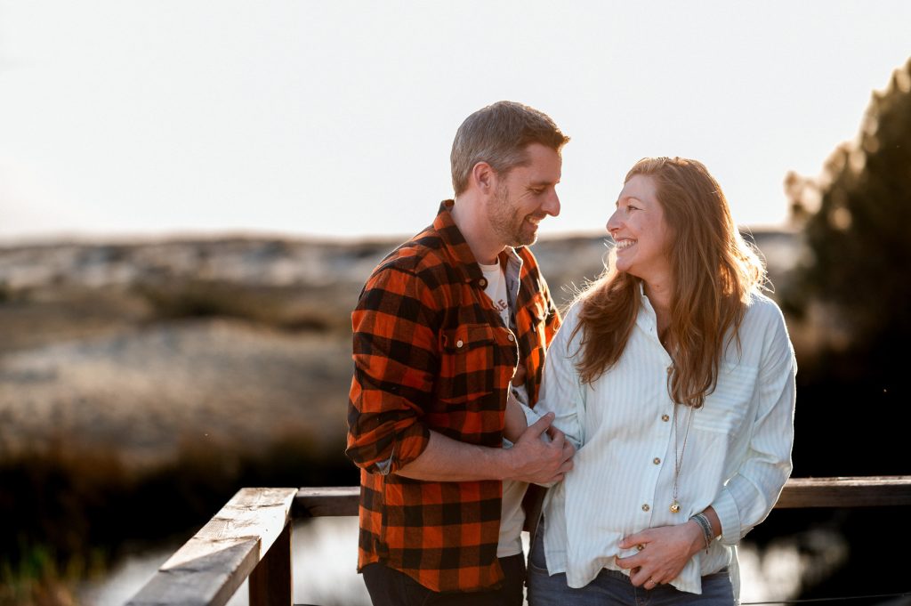 couple souriant et complice séance grossesse sur ponton Biscarrosse
