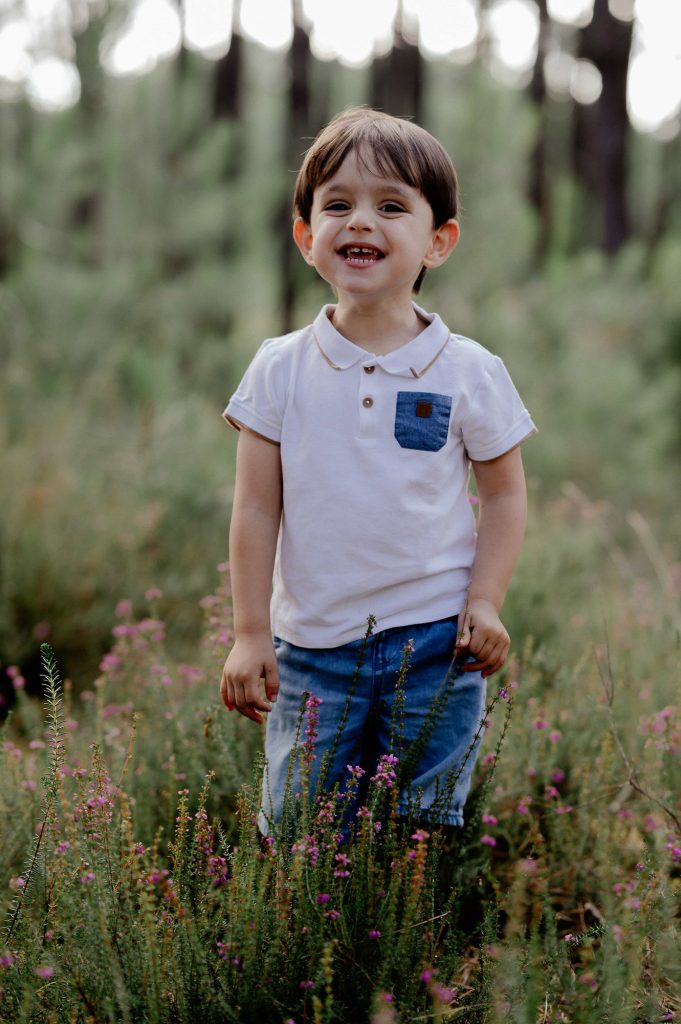 portrait d’un enfant souriant en forêt lors d’une séance photo famille à Mimizan