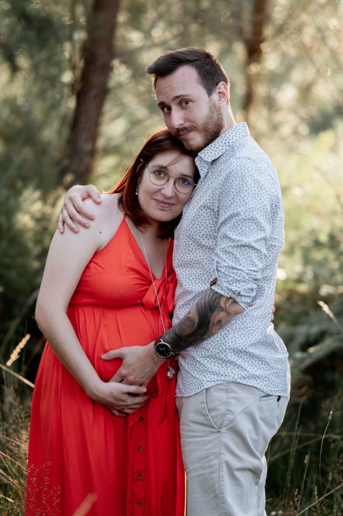 Couple en séance photo grossesse en forêt dans les Landes