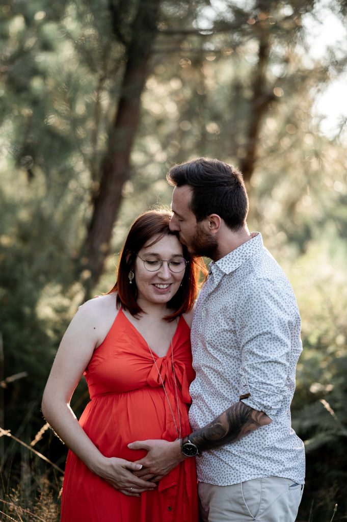 Couple en séance photo grossesse en forêt dans les Landes