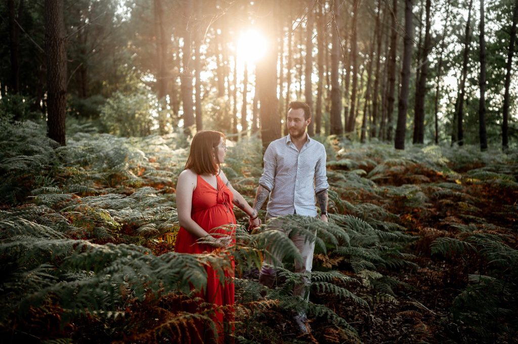 Couple en séance photo grossesse en forêt dans les Landes