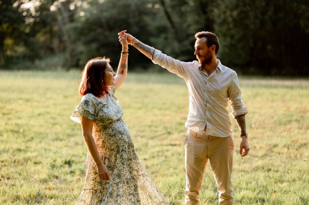 Moment complice en forêt lors d’une séance photo grossesse