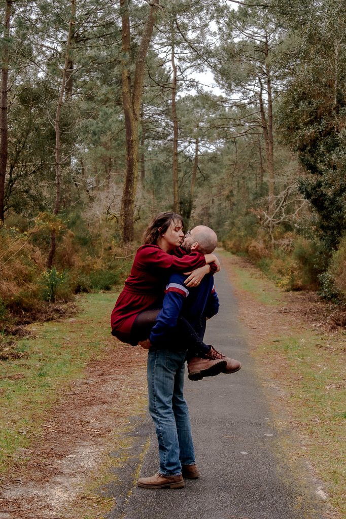 couple qui s’embrasse sur un chemin en forêt à Biscarrosse