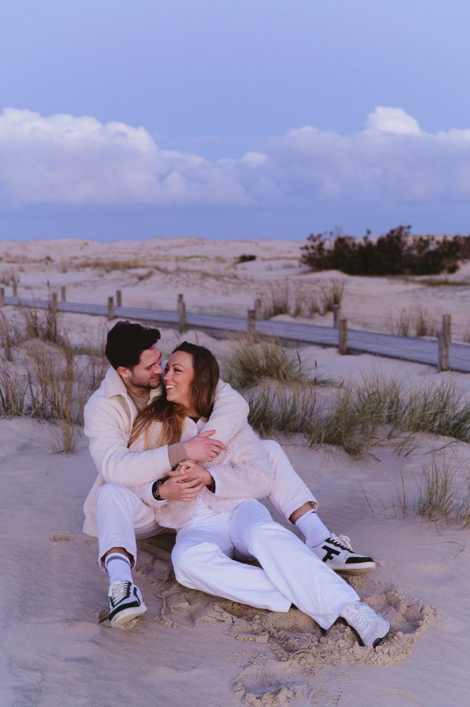 couple assis dans les dunes moment complice au lever du soleil
